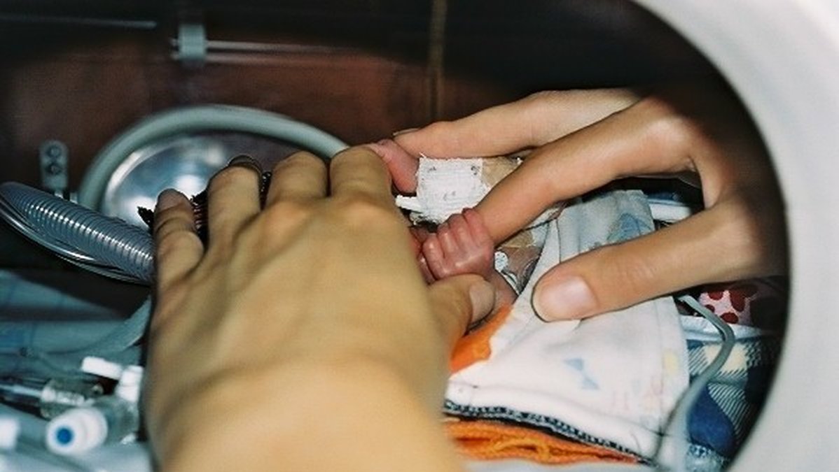 Efter hjärtoperationen, här kramar Liv mammas finger.